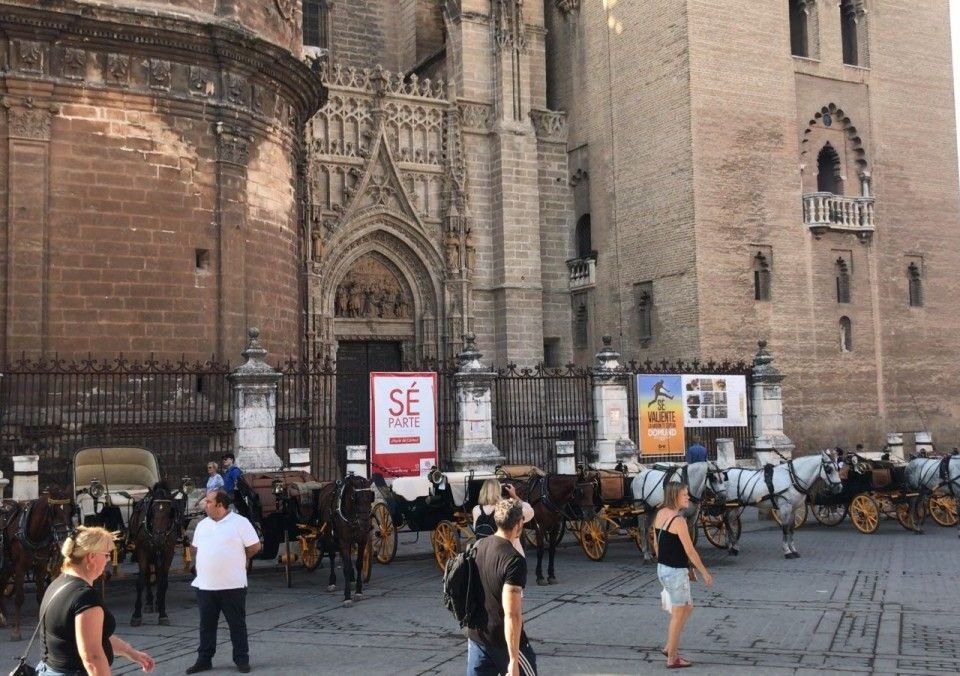 Coches de caballos estacionados en la puerta dela catedral de Sevilla.